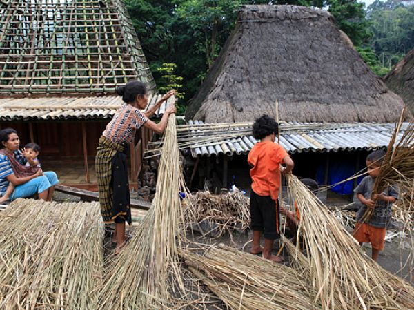 (Photo:) kobiety przygotowywują trawę na pokrycie dachu